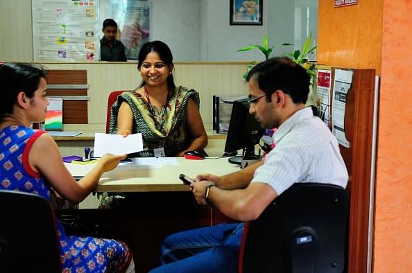 A bank official helps a customer. (Priyanka Parashar/Mint via GettyImages)